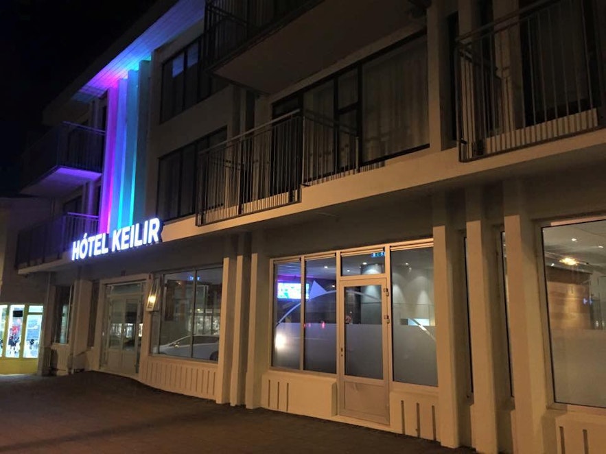 The outside of Hotel Keilir in Keflavik close to Keflavik International Airport lit up in pink and blue in the dark night