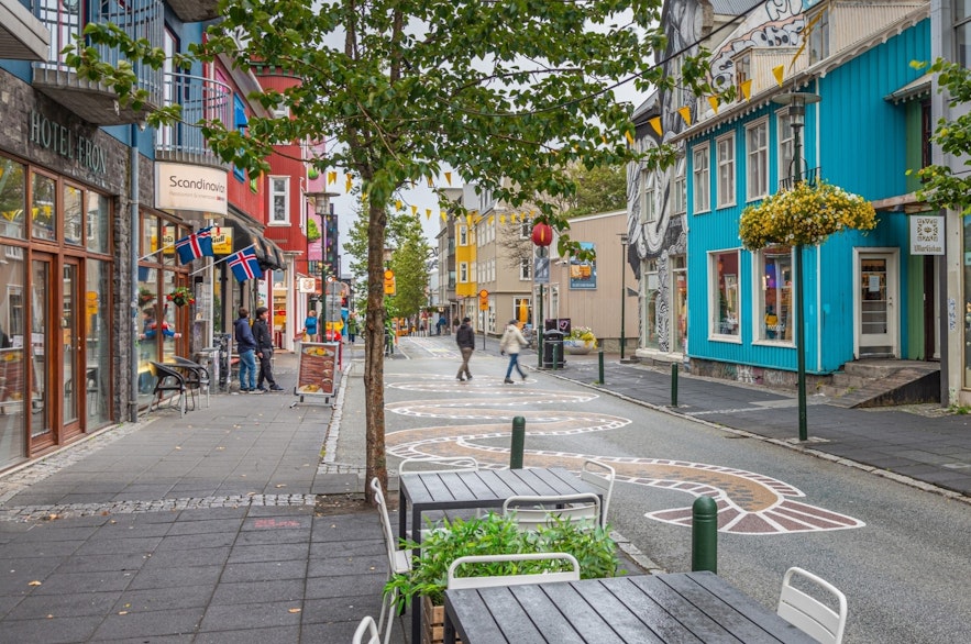 Laugavegur in Reykjavik with colorful houses and tables for sitting outside