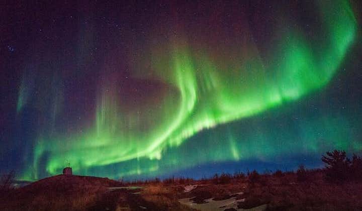 Northern Lights shimmer and dance across the night sky, illuminating the darkness with their enchanting colors.
