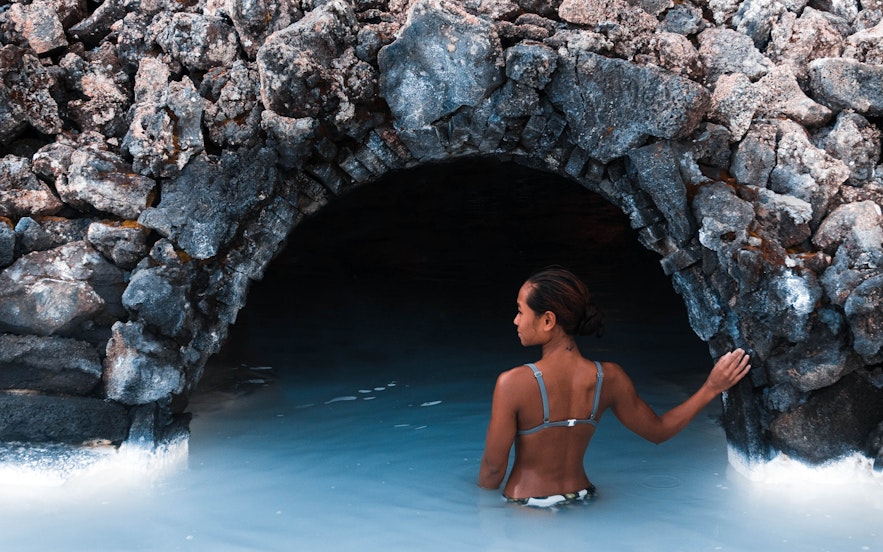 游客矗立在蓝湖温泉的一个洞穴旁