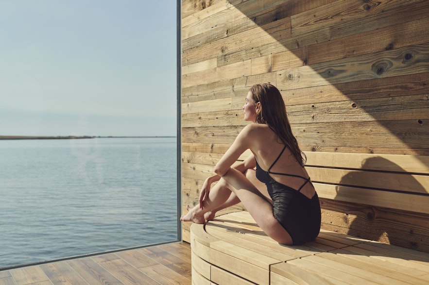 Woman enjoying the sauna with a view at the Sky Lagoon