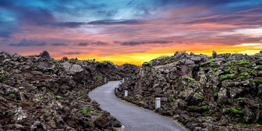 Entrance to the Blue Lagoon surrounded by lava and with a beautiful sunset in the background