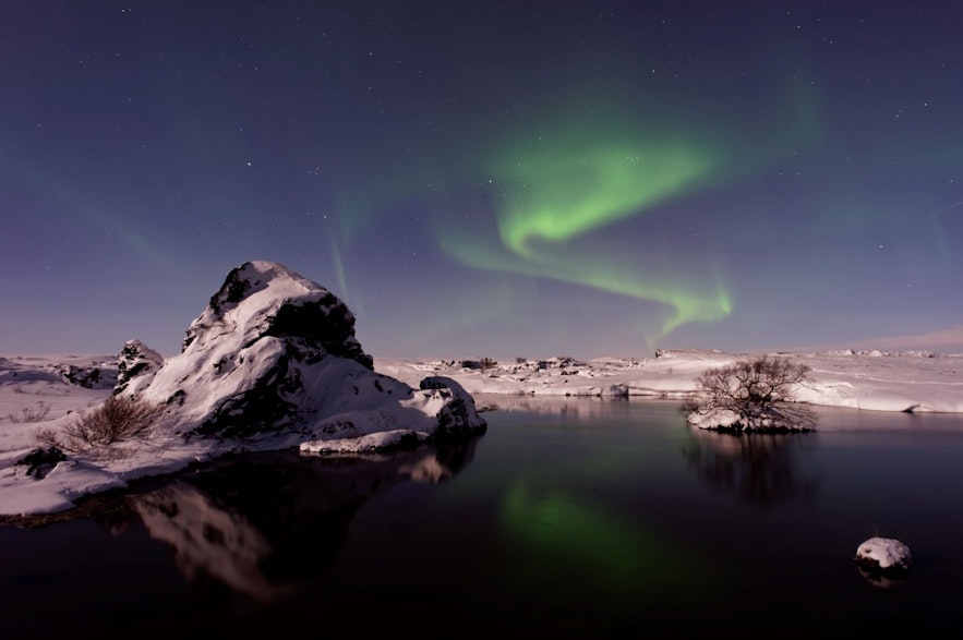 แสงเหนือเหนือทะเลสาบมิวาทน์ที่ปกคลุมไปด้วยหิมะในประเทศไอซ์แลนด์