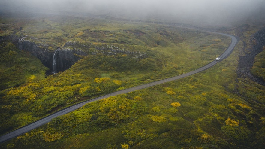 여름 아이슬란드 이스트피오르의 이끼 낀 산을\ 운전하는 자동차