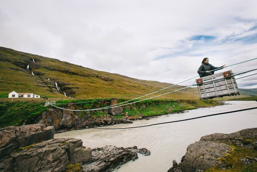Person crossing over Jokulsa glacier river in a cableway in Iceland