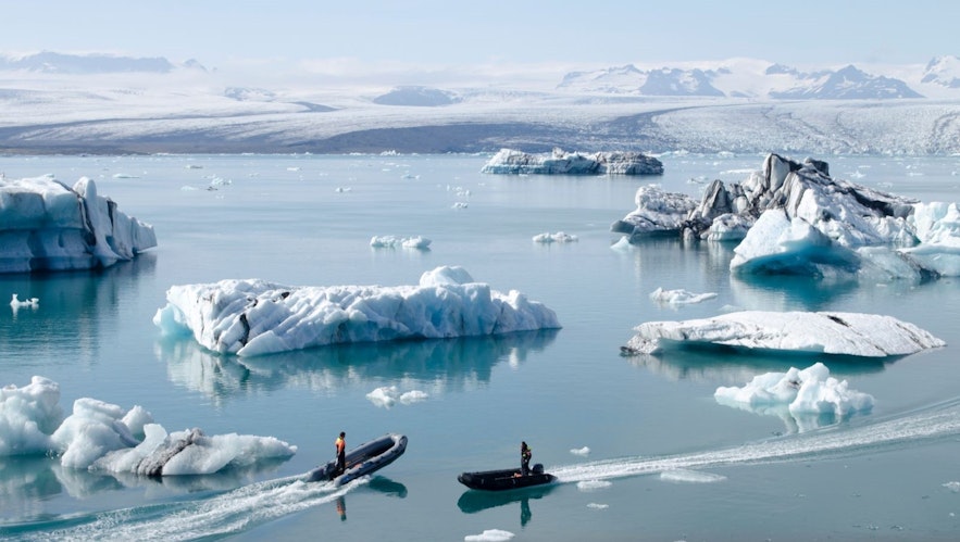 在杰古沙龙冰河湖乘船游玩的人们。