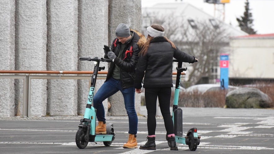 People using the Hopp app and Hopp scooters by Hallgrimskirkja in Reykjavik