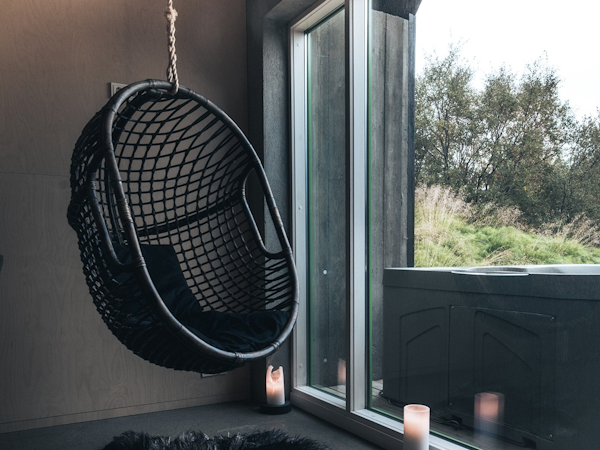 Relax and  unwind in our indoor hanging swing chair, adding a touch of whimsy to your stay at Viking Cottages and Apartments.