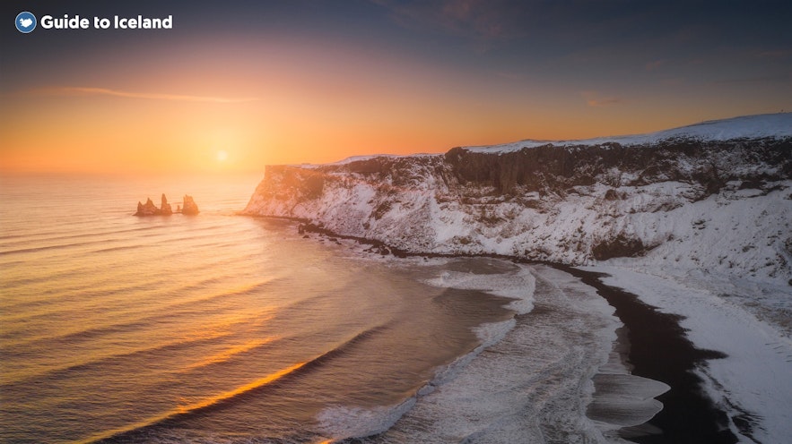 The sun setting over Reynisdrangar and the black sand beach in Iceland