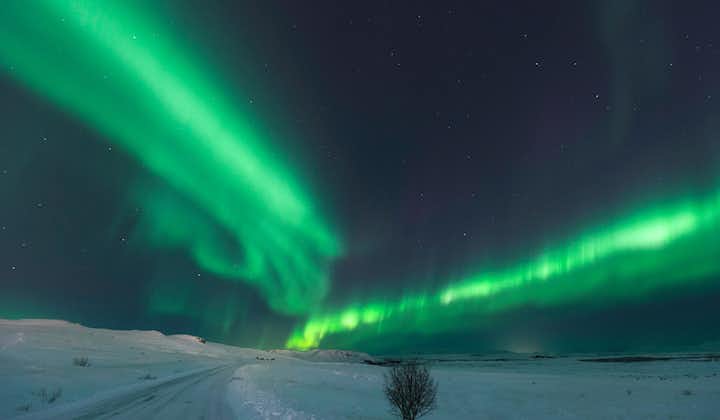 Bands of aurora borealis swirling in the countryside of Iceland.