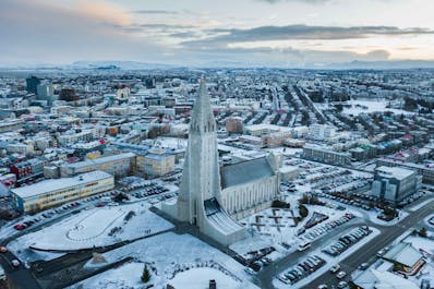 The Hallgrimskirkja church surrounded by snowy streets and landscapes in Reykjavik.