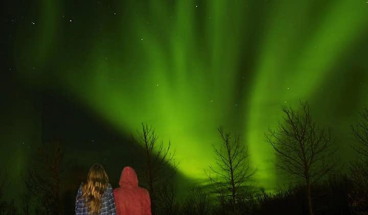 Two travelers admiring the northern lights in Iceland.