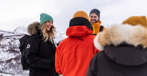 A small group of people talking and smiling on a three-day northern lights tour in Iceland.