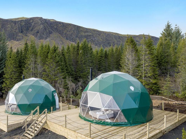 Trees and mountains surround the Golden Circle Domes in Iceland for the best glamping experience..