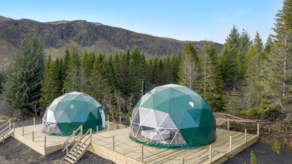 Trees and mountains surround the Golden Circle Domes in Iceland for the best glamping experience..