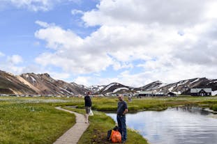 Visitors on a Super Jeep excursion enjoy the geothermal wonders and panoramic views of Landmannalaugar's expansive valley.