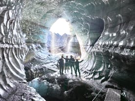A group of travelers stand inside the spectacular Katla ice cave during a guided tour.