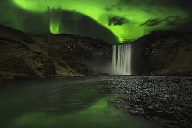Mesmerizing northern lights gracefully dance over the majestic Skogafoss waterfall, creating a truly enchanting spectacle.