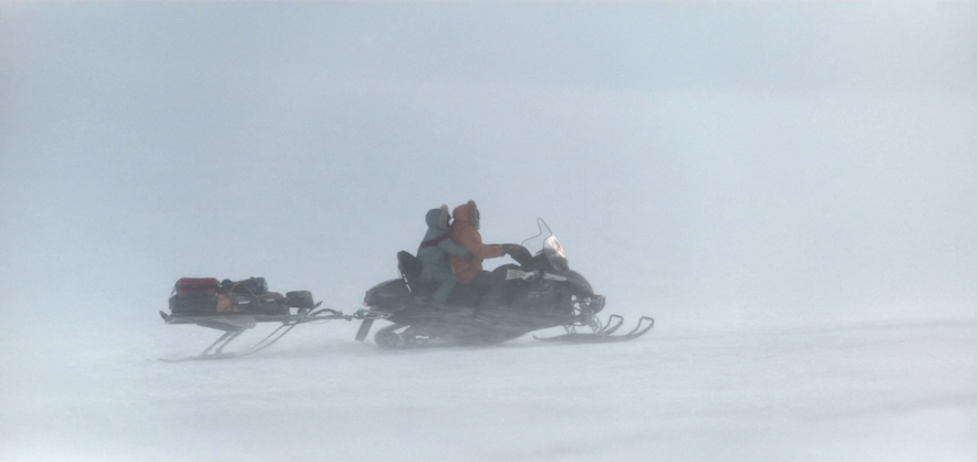 George Clooney na skuterze śnieżnym przemierza lodowiec Vatnajokull na Islandii.