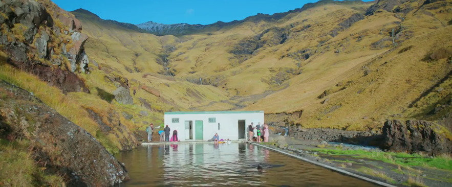 Le couple du film Through Night and Day se baignant dans la piscine de Seljavallalaug en Islande.