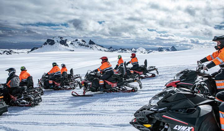 A group of snowmobilers race across the vast icy expanse of the Langjokull glacier.