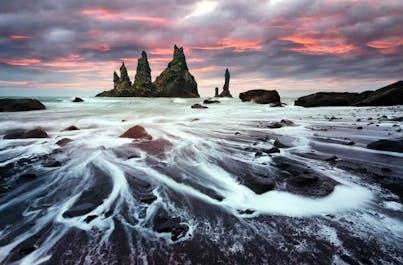 Lost in the surreal beauty of Reynisfjara beach, where black sands meet crashing waves by the wild Atlantic.