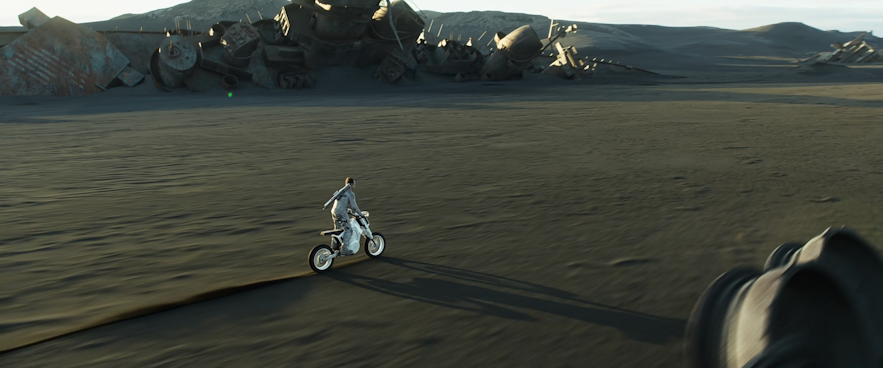 Tom Cruise rides on a motorcycle across black sand dunes in Iceland for the film Oblivion