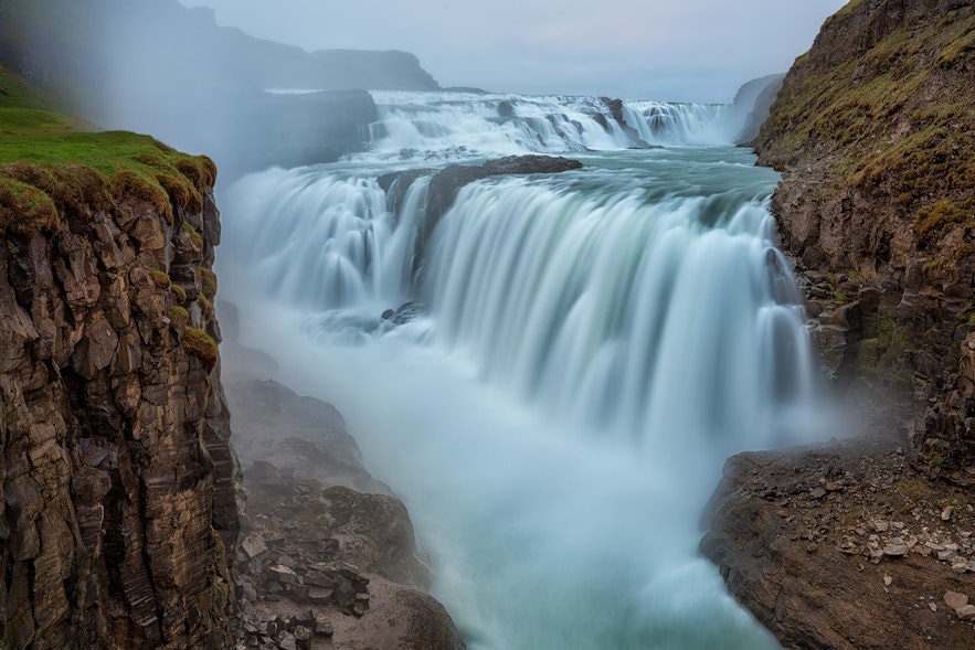 Gullfoss, najsłynniejszy i najczęściej odwiedzany wodospad na Islandii, widziany podczas każdej wycieczki po Złotym Kręgu, na zdjęciu w lecie.