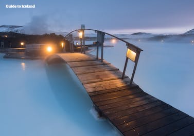 A wooden bridge over the azure waters of the Blue Lagoon geothermal spa.