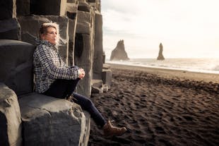 A tour joiner posing for a photo at Reynisfjara black sand beach.