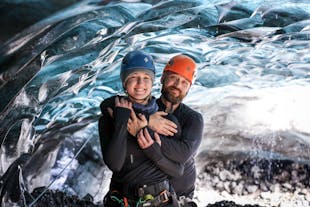 A couple poses with their arms round each other in an ice cave in Iceland.