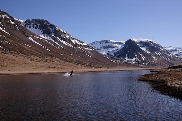 A person wakeboarding with a breathtaking mountain backdrop in the Westfjords.