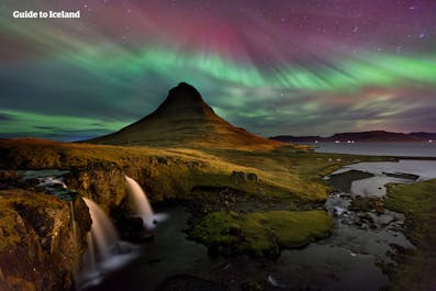 Kirkjufell mountain looks more breathtaking with the glimmer of the northern lights.