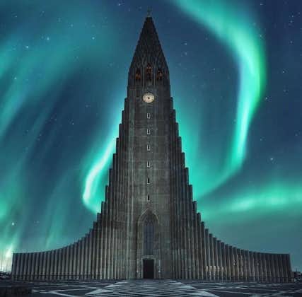 Hallgrimskirkja framed by the ethereal glow of the northern lights, blending natural wonder with architectural beauty in this captivating scene.