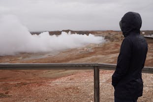 A person watches steam rising from the Earth at one of the Reykjanes Peninsula's geothermal areas.