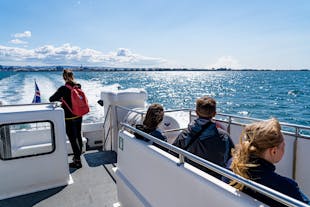 People enjoying a whale-watching tour from Reykjavik in the sunshine.