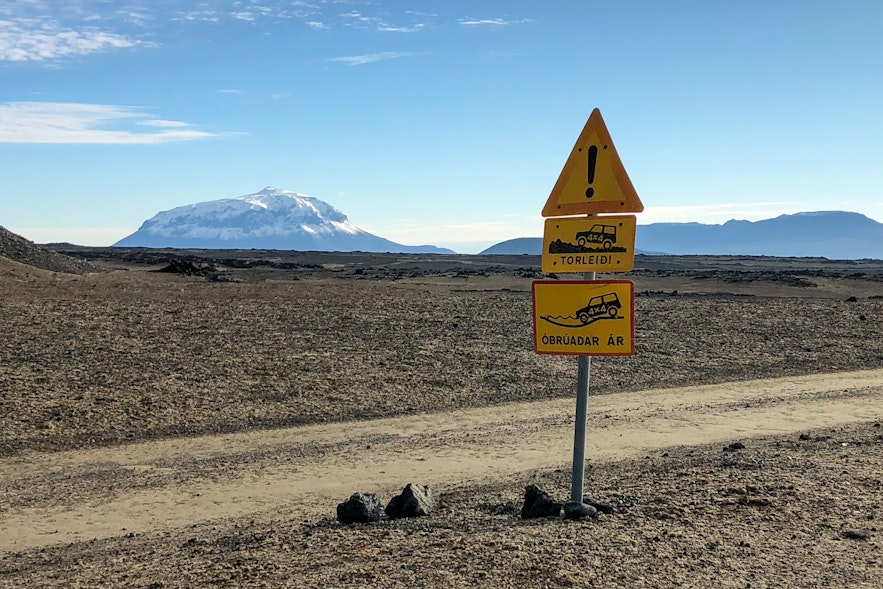 冰岛一条F级公路旁的指示牌，下方的指示牌警告前方有未贯通的河流。