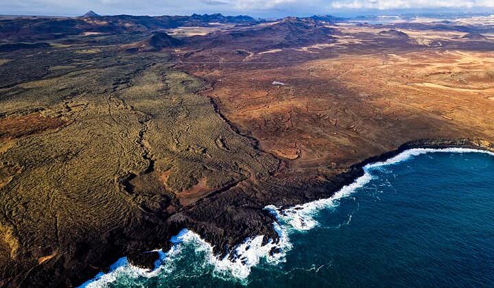 Una vista aerea dei campi di lava fino alla costa durante un tour del vulcano in elicottero.