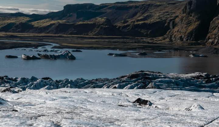 Experience the unique beauty of Solheimajokull as you hike on contrasting volcanic ashes against the pristine white and blue ice.