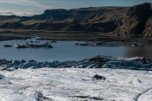 Experience the unique beauty of Solheimajokull as you hike on contrasting volcanic ashes against the pristine white and blue ice.