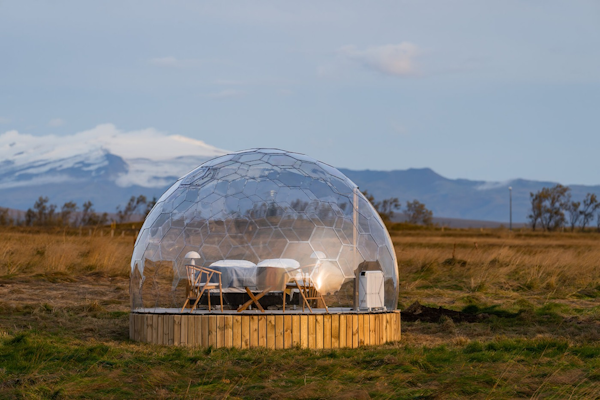 A glamping pod at Aurora Igloo, with a mountain range in the background.