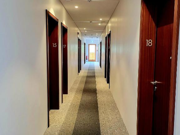 Traverse through the inviting hallway of Hotel Flokalundur.