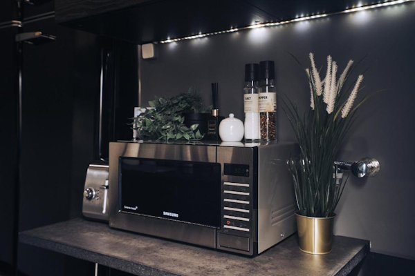 Unleash the culinary possibilities with a microwave oven and toaster in the Golden Circle Truck Hotel's kitchen—your fast-track 