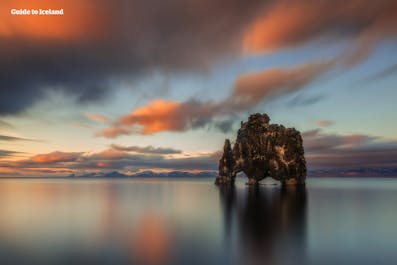 The striking Hvitserkur rock formation rises from the ocean floor at sunset.