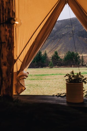 The view of the spectacular Icelandic scenery through the door of a glamping tent at the Golden Circle Tents Glamping Experience