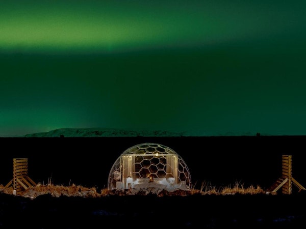 One of the Aurora Igloos under the glow of the northern lights.