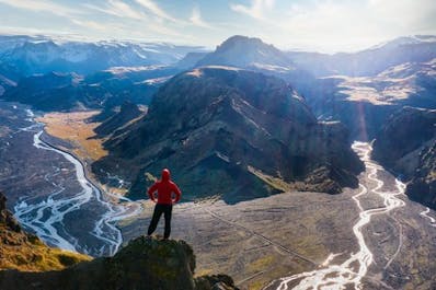 A traveler in the Thorsmork valley looks down on the glacial rivers flowing through the valley below.