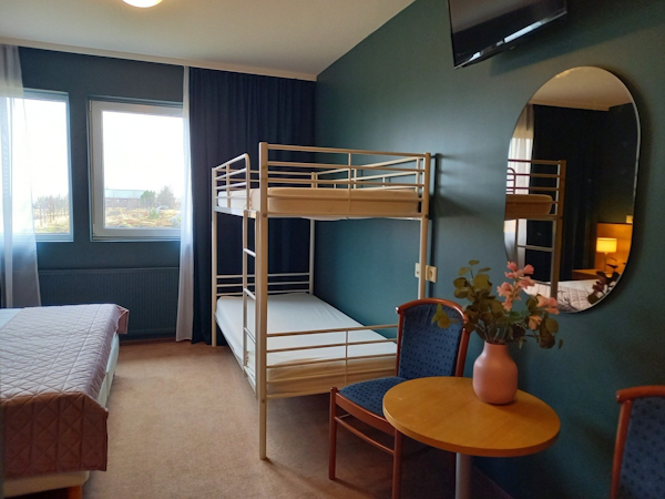 The family rooms at Hotel Kvika have a double bed and a set of bunk beds, plus a table and chair for comfort and convenience.