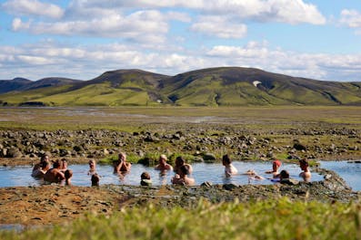A group of adventurers taking a relaxing dip in a natural pool.