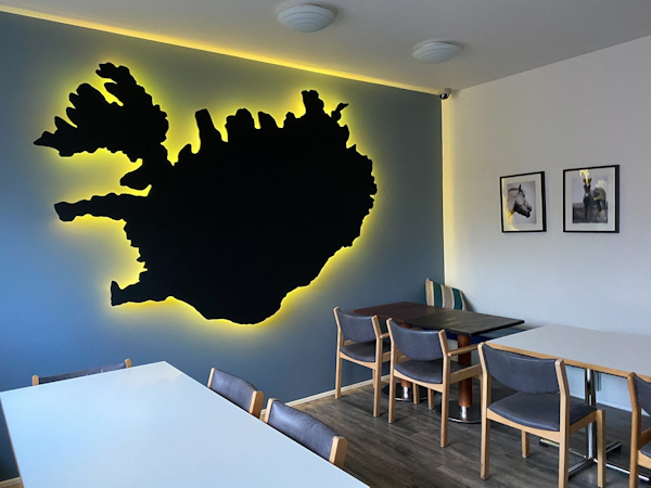 The hostel's common area boasts an artistic wall design featuring a map of Iceland.